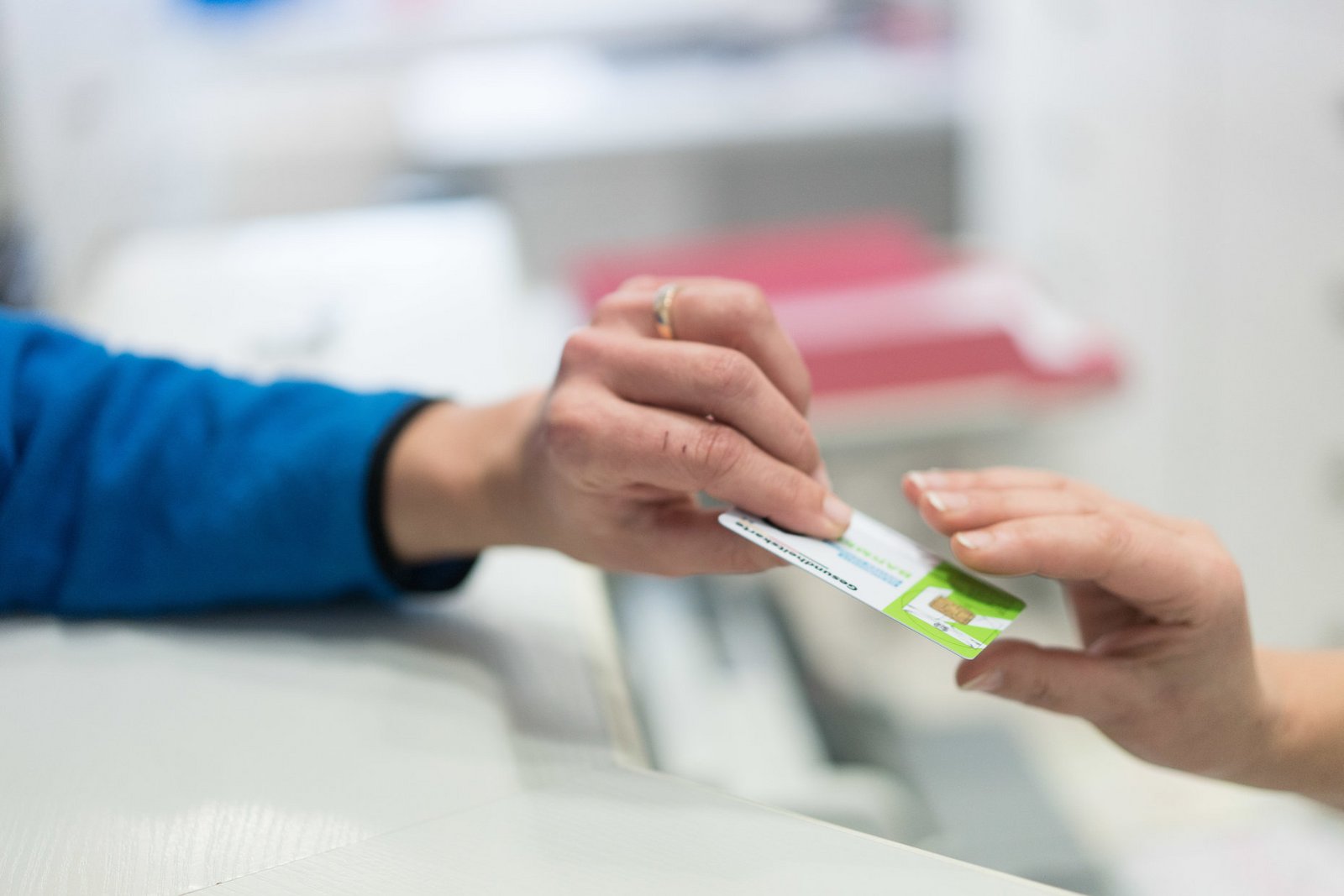 Patient überreicht die Chipkarte der Krankenkasse 